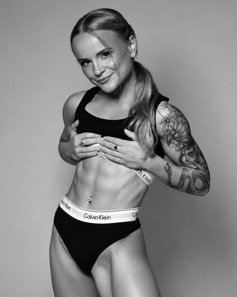 Aurelija, personal trainer, in a black and white studio portrait
