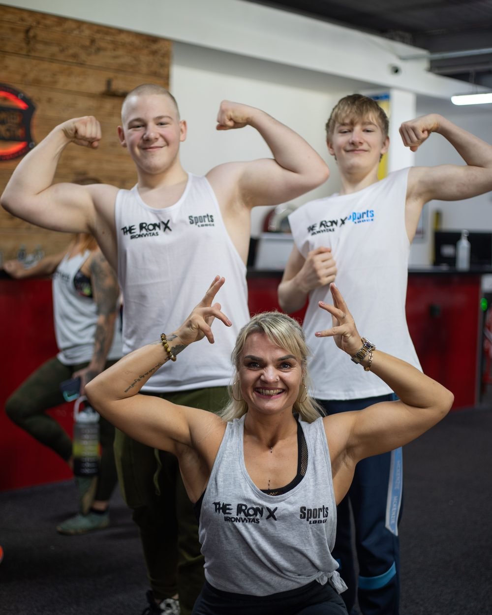 Three Sports Lodge athletes flexing together in the gym
