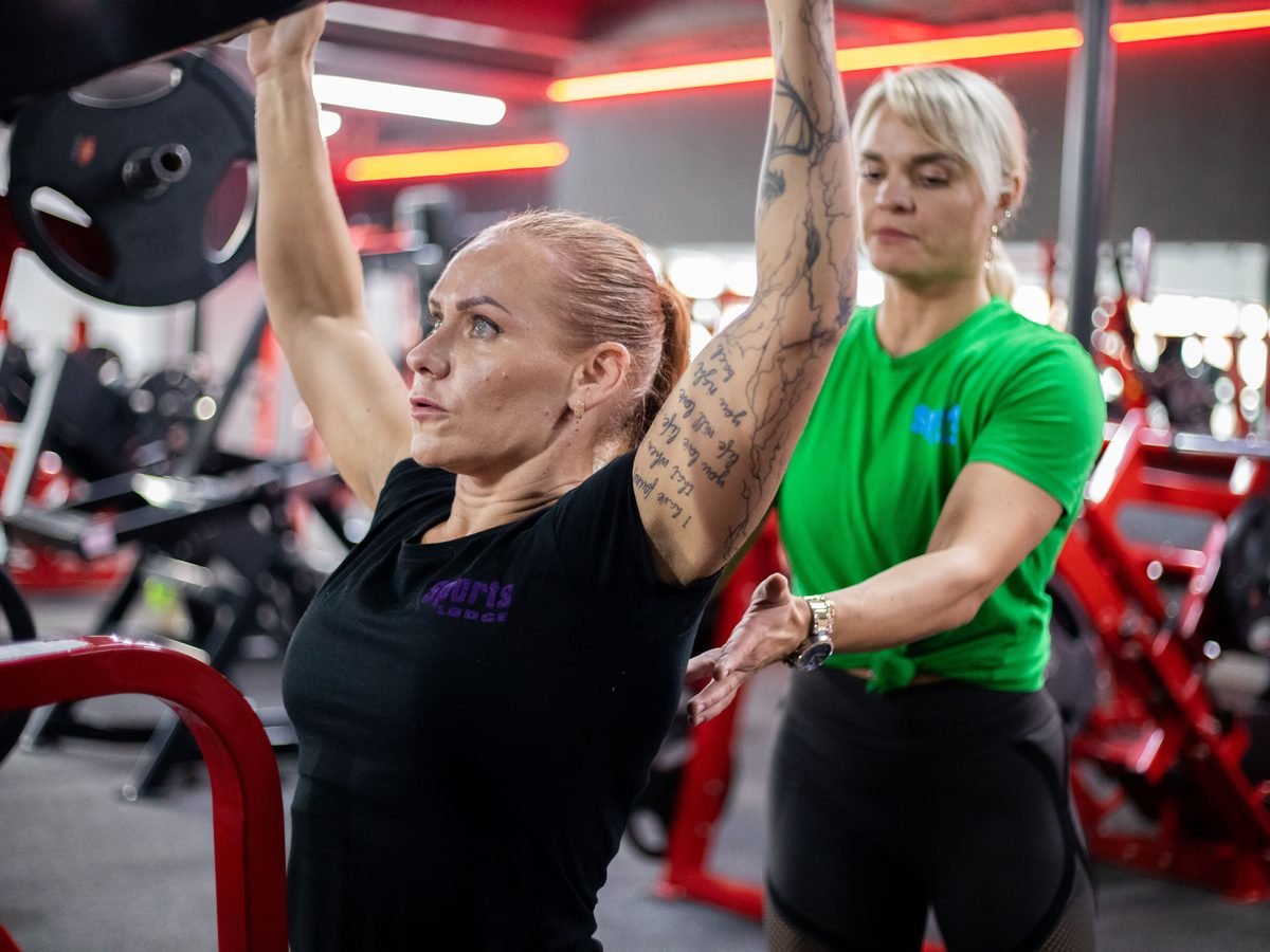 Coach guiding a member through a pull-up