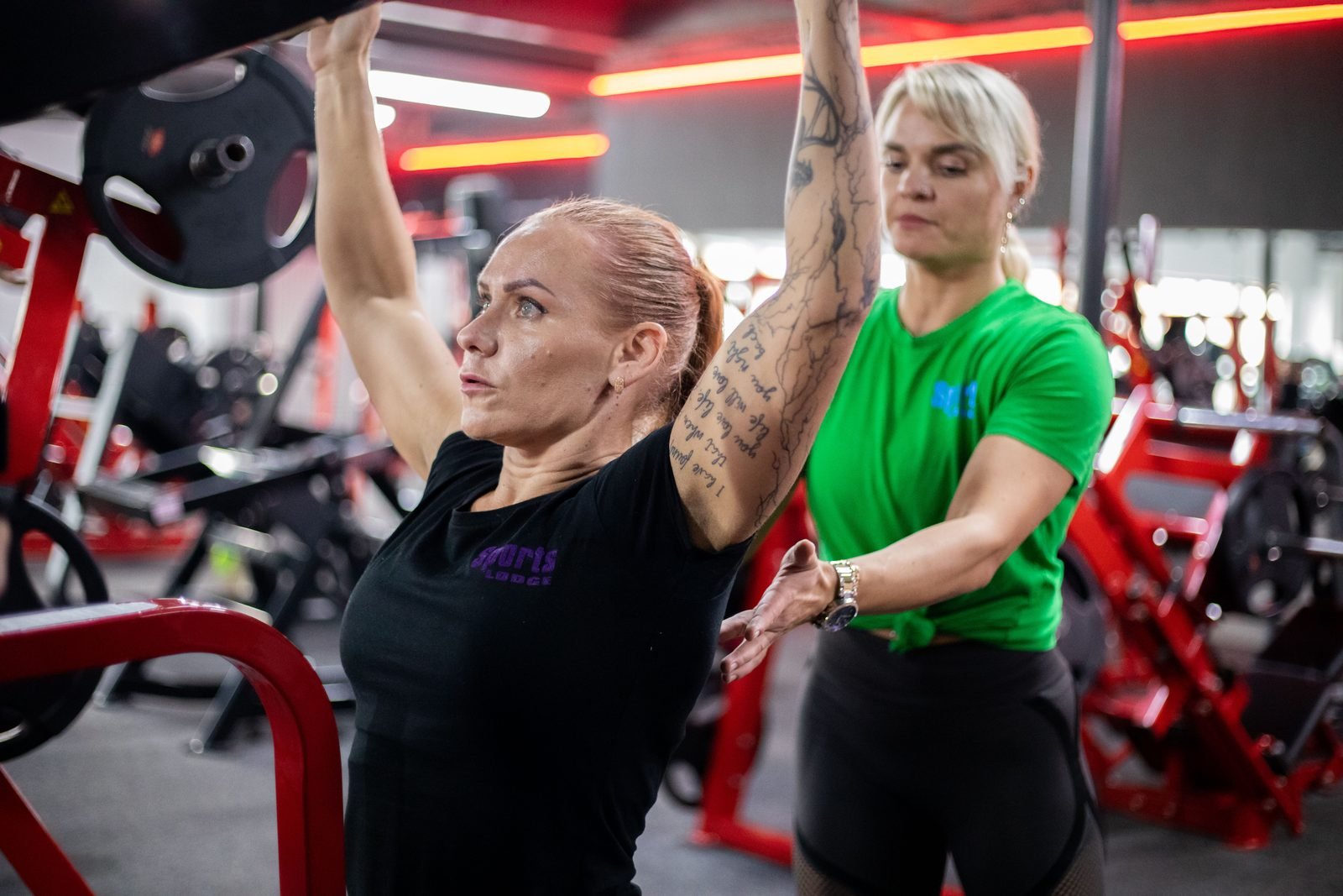 Coach guiding a gym member through a pull-up