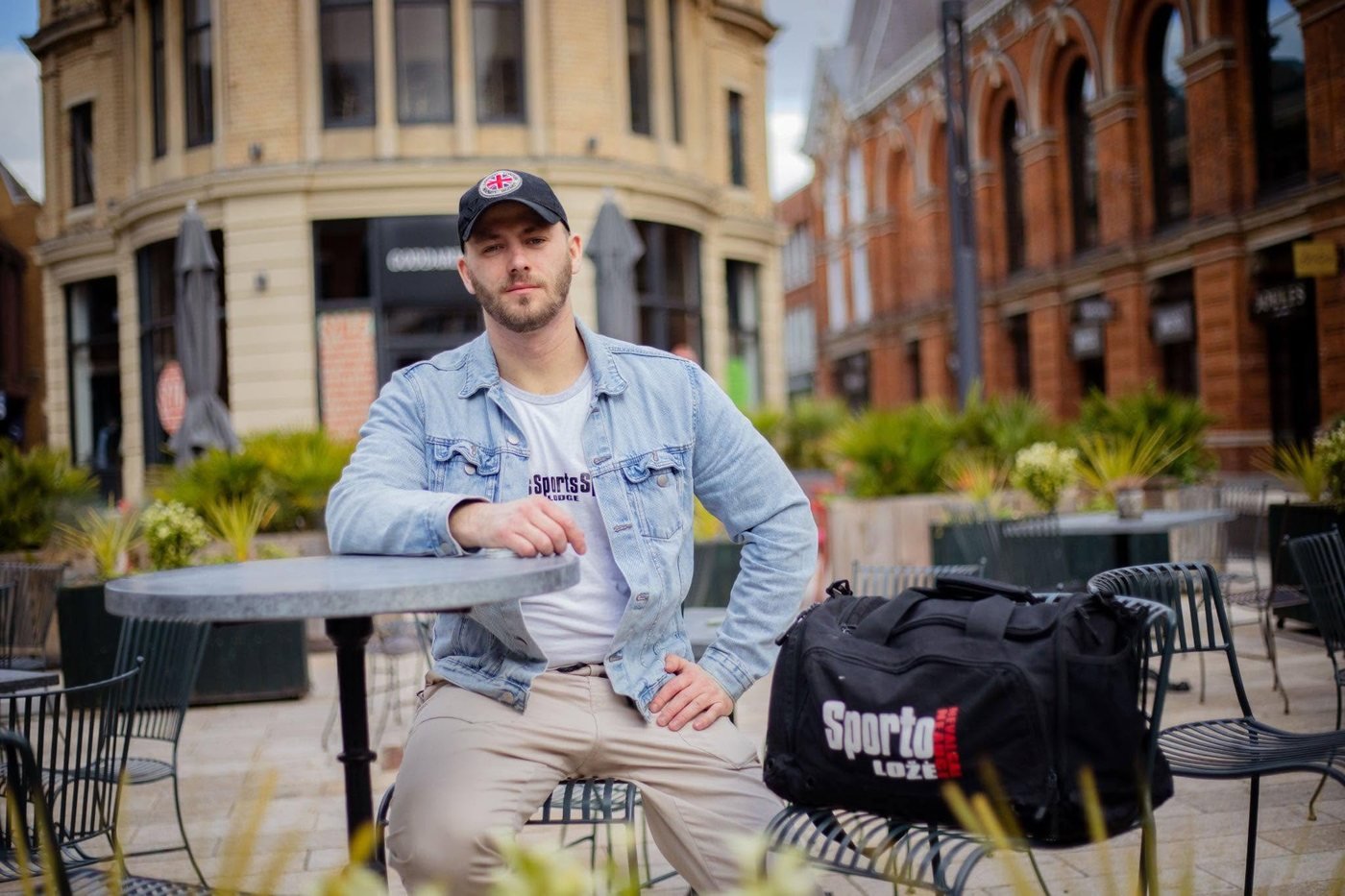 Karolis Stasiūnas, founder of Sports Lodge, sitting outside in a Sports Lodge t-shirt