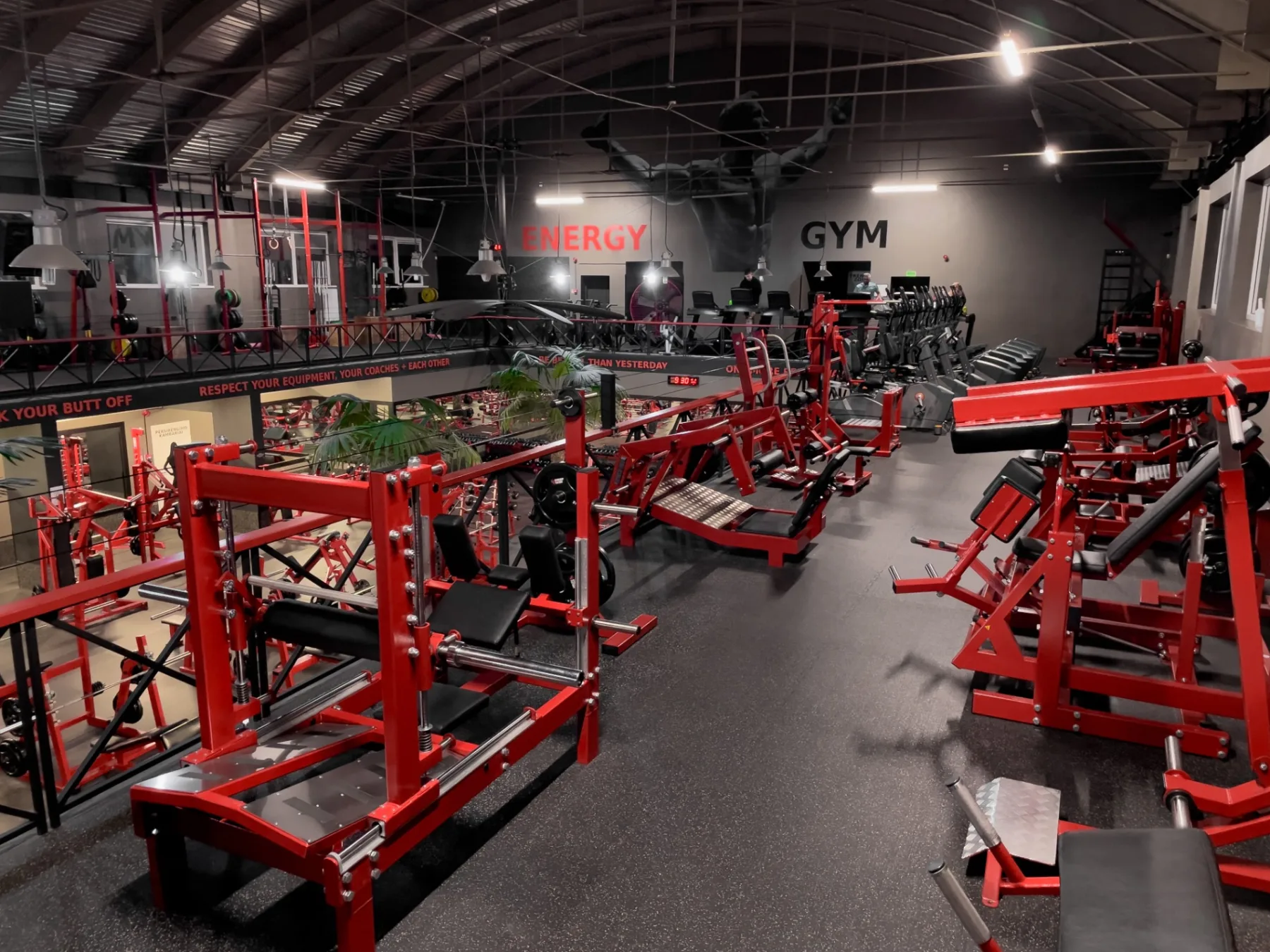 Energy Gym in Šiauliai, Lithuania, fitted out with red Gym Factory plate-loaded machines on a mezzanine above the main floor